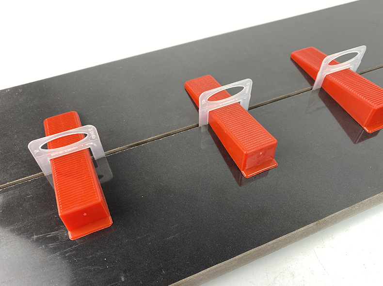 Customized tile positioning and leveling device base, reusable tile positioning and leveling device base, tile laying tool, oblique insertion
